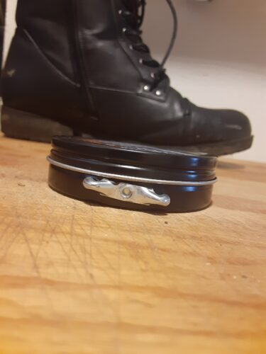 Knob on the side of shoe polish tin